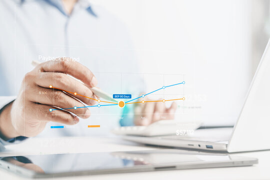 Business professional using stylus analyzing payback period and break even pointon on tablet and laptop, financial chart , revenue and cost comparison, ROI decision making, corporate finance analytics