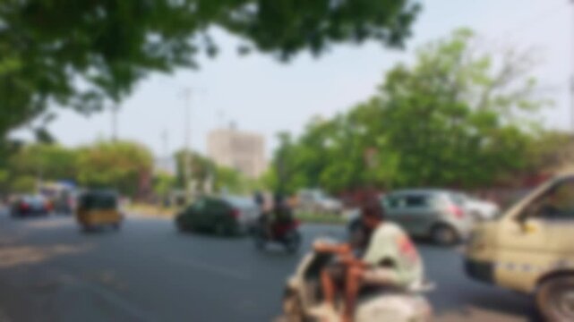 Defocused traffic flow on Secretariat Road near Iqbal Minar Circle in Hyderabad with urban transport, city movement and blurred background scene during daytime.