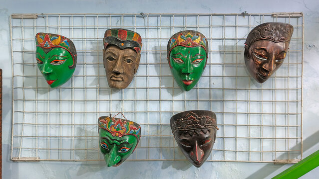 hand-carved wooden Indonesian masks decorated with colorful batik patterns and character expressions from Javanese and Balinese folklore. Close up view.