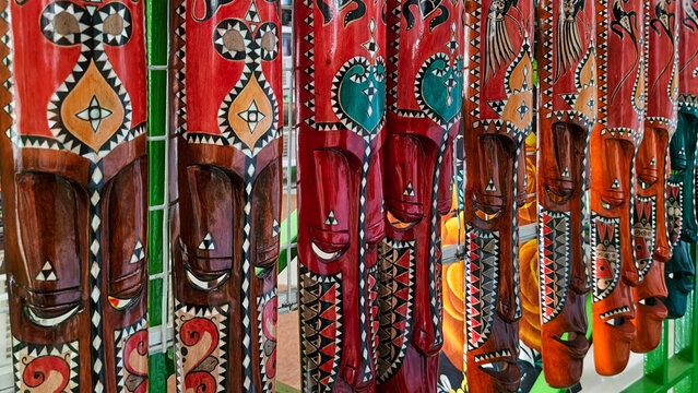 hand-carved wooden Indonesian masks decorated with colorful batik patterns and character expressions from Javanese and Balinese folklore. Close up view.
