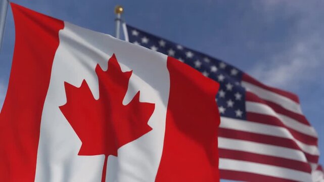 Canadian and American flags flying together outdoors, symbolizing friendship, cooperation, shared values, and enduring partnership under clear blue sky
