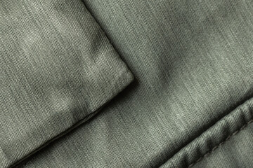 Naklejka premium Close-up of folded green fabric revealing detailed textile texture, padded quilting and visible stitching; versatile background for design, upholstery, fashion, material studies and soft home decor