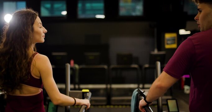 Friends work out together at a fitness center while sharing exercises and encouragement in a fun group setting