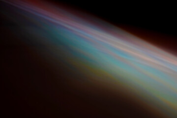 An abstract image with faint, blurred bands of color ranging from red and blue to green, creating an iridescent texture. © Israel AG