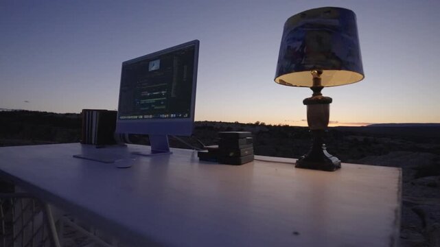 Desktop Editing Workspace in Desert at Blue Hour with Glowing Lamp