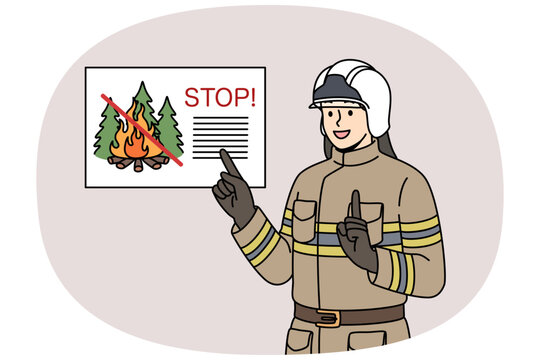 Man firefighter reminds of ban on lighting fires in forest, standing in work uniform and helmet. Professional firefighter smiles agitating not to start fires in parks while walking.