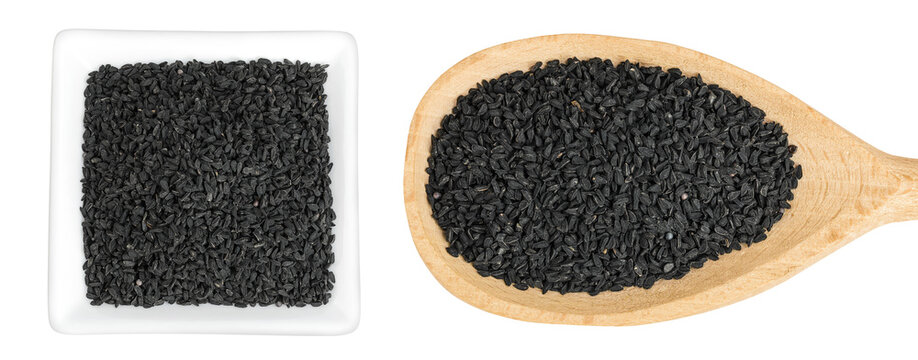 Nigella sativa or Black cumin in ceramic bowl and wooden spoon isolated on white background. Top view. Flat lay.