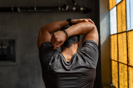 Man stretching in industrial gym.