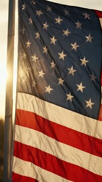 USA Flag Waving in Golden Sunlight - A close-up shot of the United States flag gently waving in the wind during sunset.