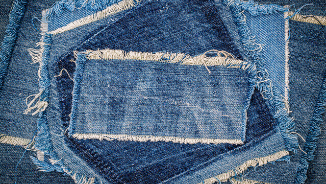 Different pieces of denim fabric arranged in a circular pattern with frayed edges indoors