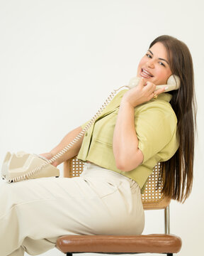 Smiling Woman Talking on Vintage Telephone on White Background
