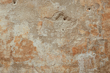 Fototapeta premium Horizontal beige plaster wall texture with rough surface, chipped areas and aged details, abstract background, copy space, wide composition