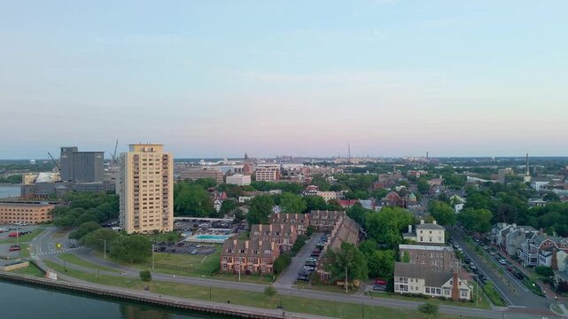 Portsmouth, Virginia, scenic 4K aerial video establishing the historic Olde Towne waterfront and residential district along the Elizabeth River during a quiet golden hour sunset.