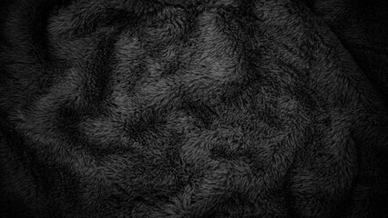Texture of a soft black blanket on a dark background showing fluffy fibers and patterns © Fleuronica