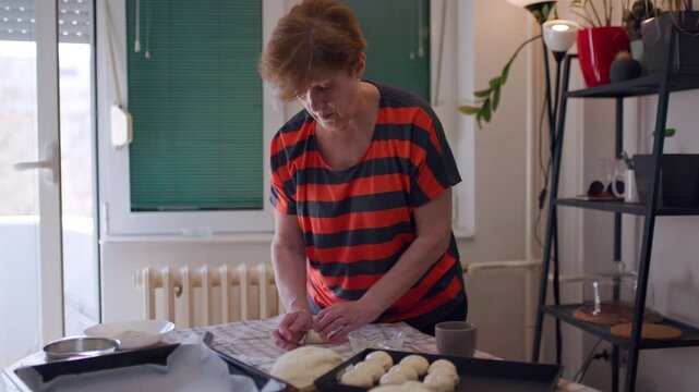 Elderly Woman Making Homemade Bread: Rolling Dough in the Kitchen, Demonstrating Traditional Cooking Methods