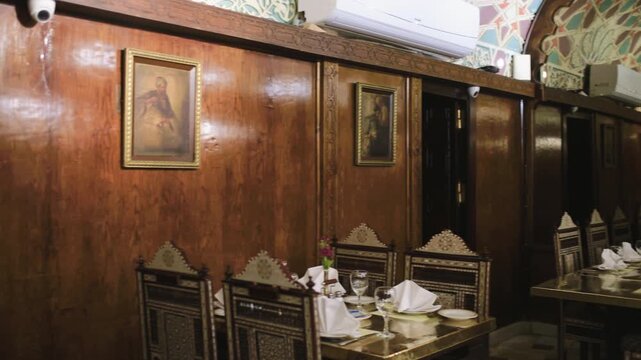 Slow motion 4K video of a traditional restaurant interior in Cairo, Egypt, featuring ornate wooden decor, elegant dining tables, and authentic Arabic design.