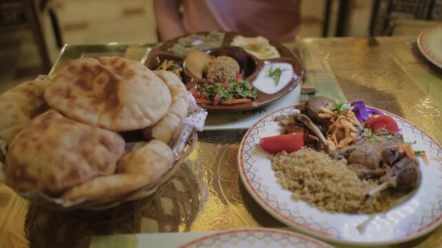 Slow motion close-up of traditional Egyptian dishes and fresh pita bread served at authentic restaurant in Cairo, Egypt. Delicious Middle Eastern cuisine.