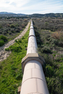 Vertical view of large water pipe crossing a river valley in Southern California.