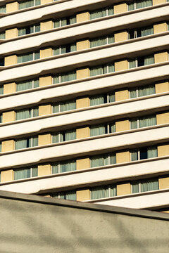Repetitive hotel facade creates horizontal rhythm over diagonal foreground wall