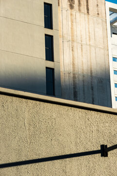 Layered urban facades align stained concrete and narrow window rhythm above wall