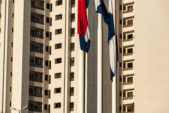Residential towers and flagpoles create vertical repetition in warm urban light