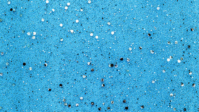 Colorful blue surface with shiny round objects scattered across the area in a random pattern