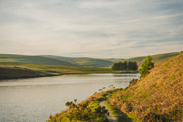 Naklejka premium Scenic Reservoir Shoreline and Rolling Hills in Rural England