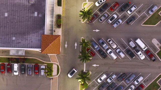 Busy supermarket and department store complex with full parking lot and customers moving between stores. Demand, commerce and everyday consumer lifestyle concept.