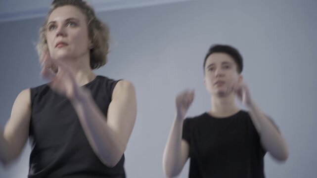 Two women practicing martial arts and taekwondo in a gym. Female self defense training focused on fitness, discipline, confidence and combat techniques in modern sports studio.