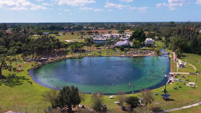 Warm mineral springs attraction with calm turquoise water, swimmers, and sunlit landscape, representing recreation, tourism, and holistic health treatments.