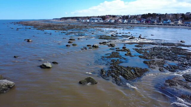 Natural spring landscape filmed by drone over the rocky coast of Saint-Ulric-de-Matane where floodwaters reach the St. Lawrence River in Quebec, Canada.