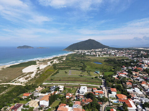 Aerial view of Santinho beach urban area near Jacare lagoon with Costao do Santinho resort and Aranhas island in Florianopolis, Brazil