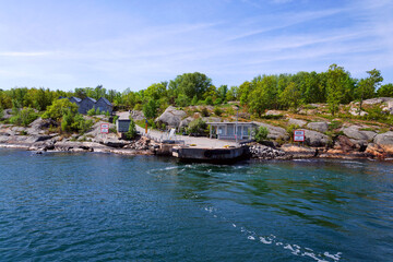Fototapeta premium Beautiful holiday cottages on shore of Gothenburg archipelago islands, Gothenburg Minucipality, Vastra Gotaland County, Sweden, sunny day
