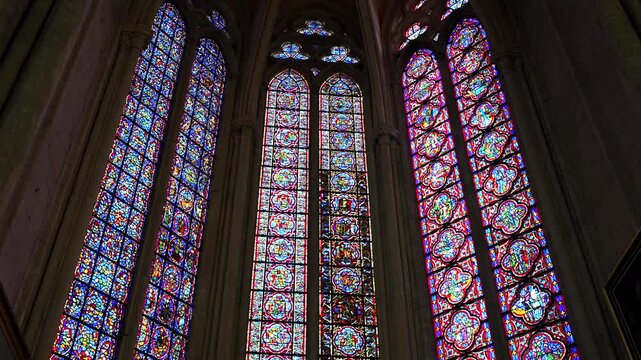 Colorful stained glass windows with gothic tracery inside Amiens Cathedral