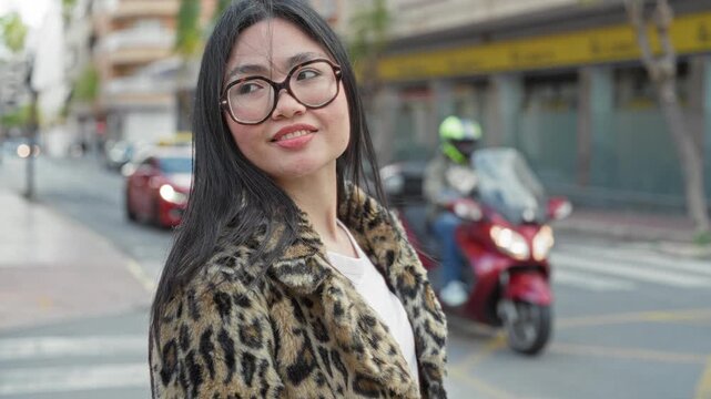 Woman wearing glasses smiling and looking over shoulder, leopard coat visible on street; confidence urban.