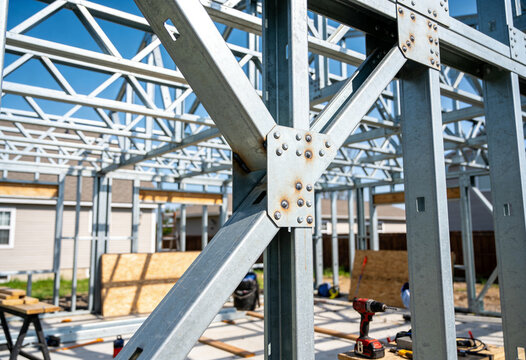 A close-up view of the structural steel framework of a residential house under construction.