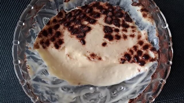 Creamy vanilla pudding dessert in glass bowl motion video clip