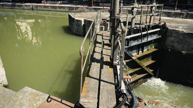 Water lock in the city center regulating the water level in an urban canal used for leisure boats and sightseeing walks. High quality 4k footage
