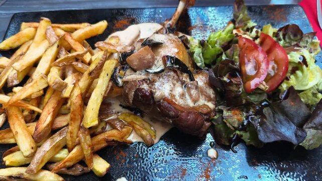 Traditional French confit de canard served with French fries and fresh green salad. Gourmet duck dish in a restaurant. High quality 4k footage