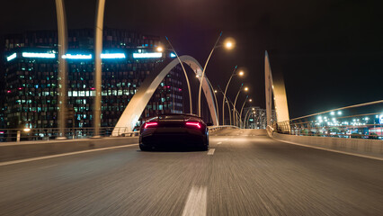 Supercar driving fast over urban bridge at night © Chris M