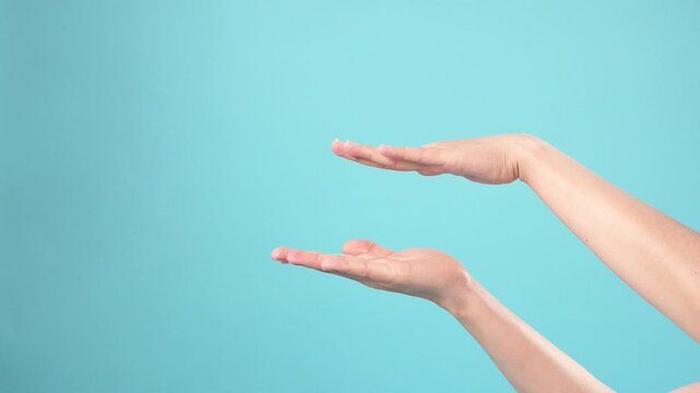 Hands moving showing something in size or scale in front of the camera shot