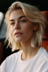 Fototapeta premium Natural close-up portrait of a young blonde woman in a car with soft daylight for magazine cover or portrait background