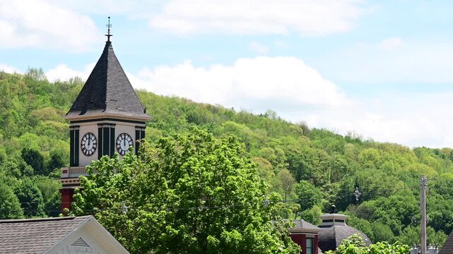 Bradford Pa small historic town city hall clock tower on lush green tree background, spring summer weather