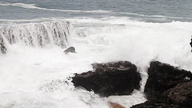 Powerful Ocean Waves Crashing Against Dark Coastal Rocks
