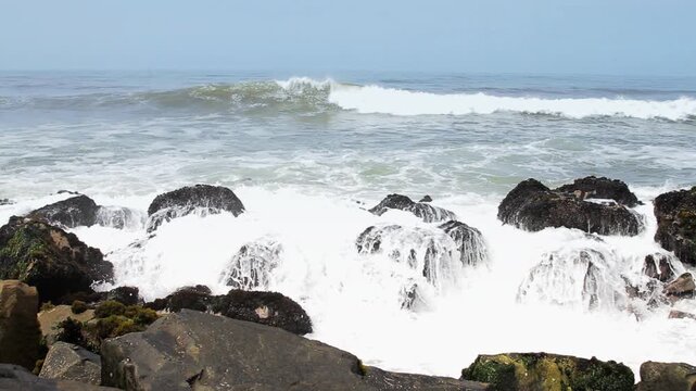 Powerful Ocean Waves Crashing Against Dark Coastal Rocks
