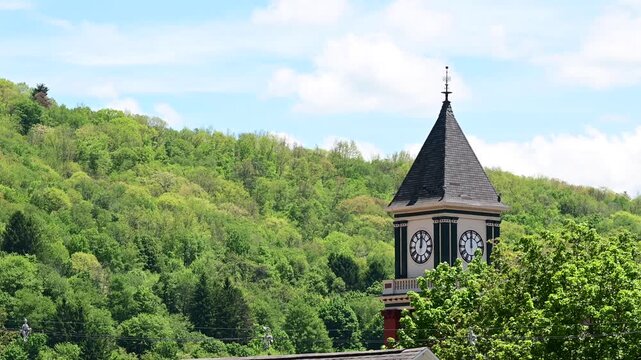 Bradford Pa small historic town city hall clock tower on lush green tree background, spring summer weather