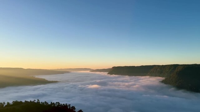 Cinematic aerial sunrise view above cloud. Misty mountain valley, forested cliffs. Blue sky horizon and serene nature. Travel tourism landscapes videos and scenic footage. Nongjrong, east khasi hills