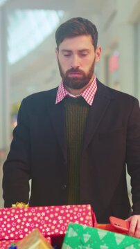 Buyer contemplates gifts, Man analyzes his shopping choices and evaluates whether they fit his financial plan