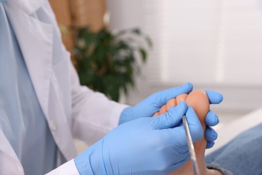 Woman undergoing toenail treatment during visit to podiatrist in clinic, closeup