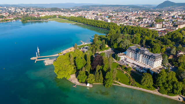 Scenic panoramic view of Annecy town nestled between green mountains and crystal clear water